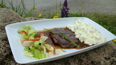 Gegrillte Walfleisch mit Salat, Kartoffelsalat und Pfeffersauce