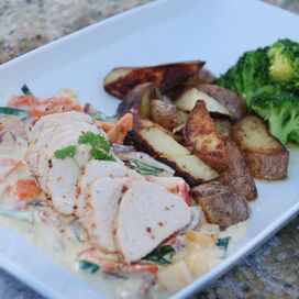 Pork fillet with vegetables, fried potatoes and creamy sauce